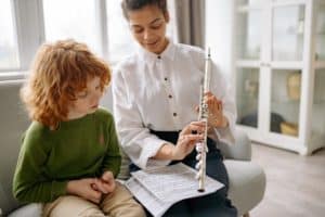 Vrouw leert kind muziekinstrument spelen